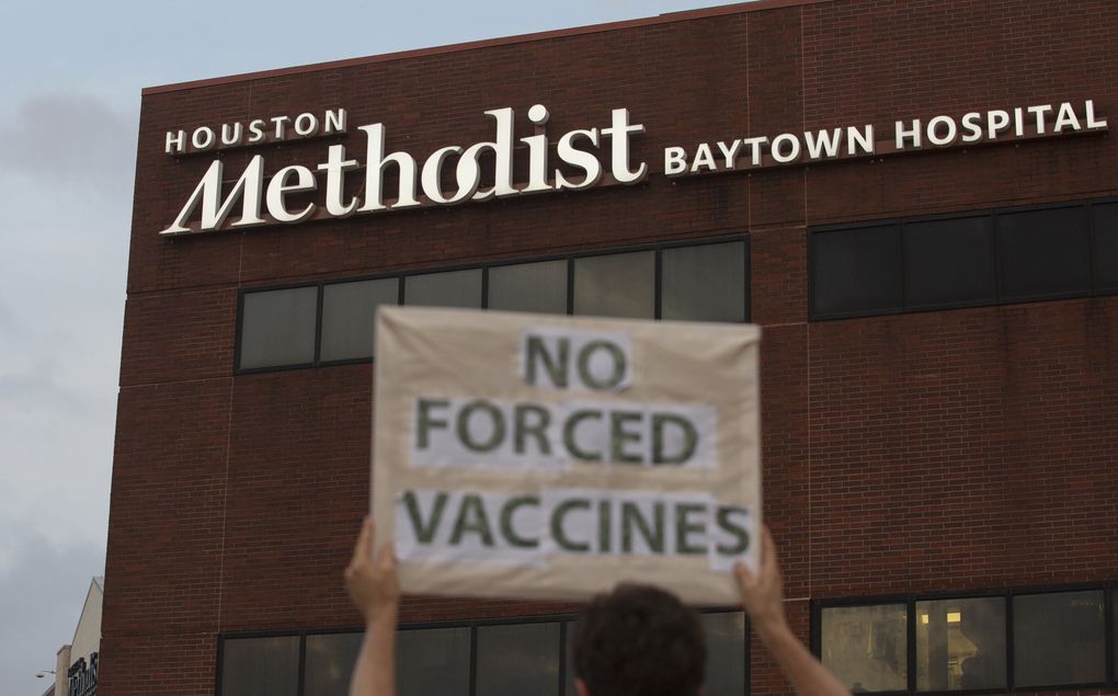 People bring signs to protest Houston Methodist Hospital system’s rule of firing any employee who is not immunized by Monday, June 7, 2021, at Houston Methodist Baytown Hospital in Baytown, Texas. Houston Methodist staff who have refused the COVID-19 vaccine so far and their supporters participated in a gathering and march. (Yi-Chin Lee / The Associated Press)