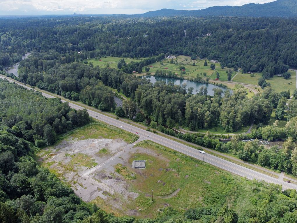 This barren lot next to Renton-Maple Valley Road is the site of Lakeside’s proposed asphalt plant. On the other side of the road, the Cedar River gently snakes through trees Tuesday. The river, not to be confused with a pond in the background, is salmon habitat. (Ken Lambert / The Seattle Times)