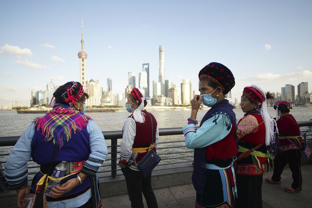 Visitors look at the Pudong skyline as they stand on the Bund in Shanghai, China, Thursday, Nov. 12, 2020. (The Associated Press)