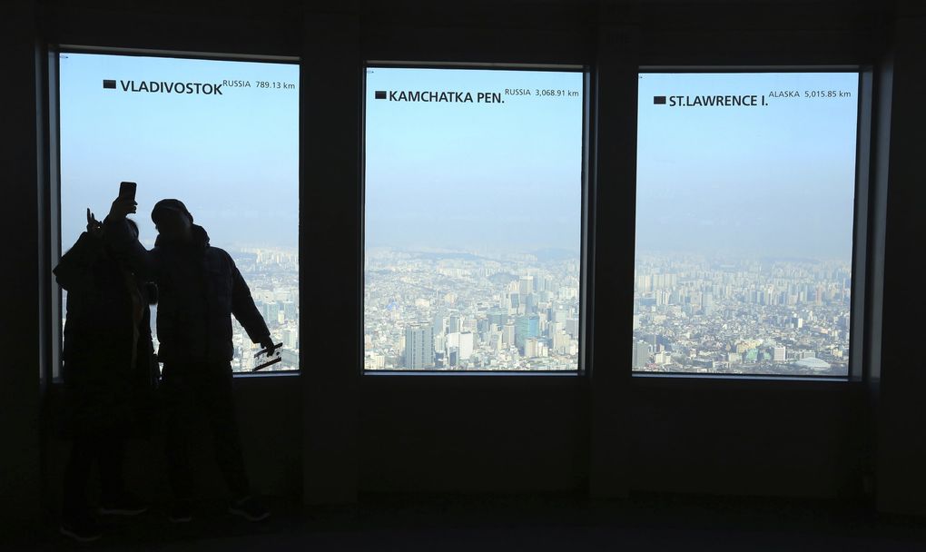 A couple takes pictures of the city skyline covered with a thick haze caused by fine dust at N Seoul Tower’s observation deck in Seoul, South Korea, Sunday, Jan. 13, 2019. (Ahn Young-joon / The Associated Press)
