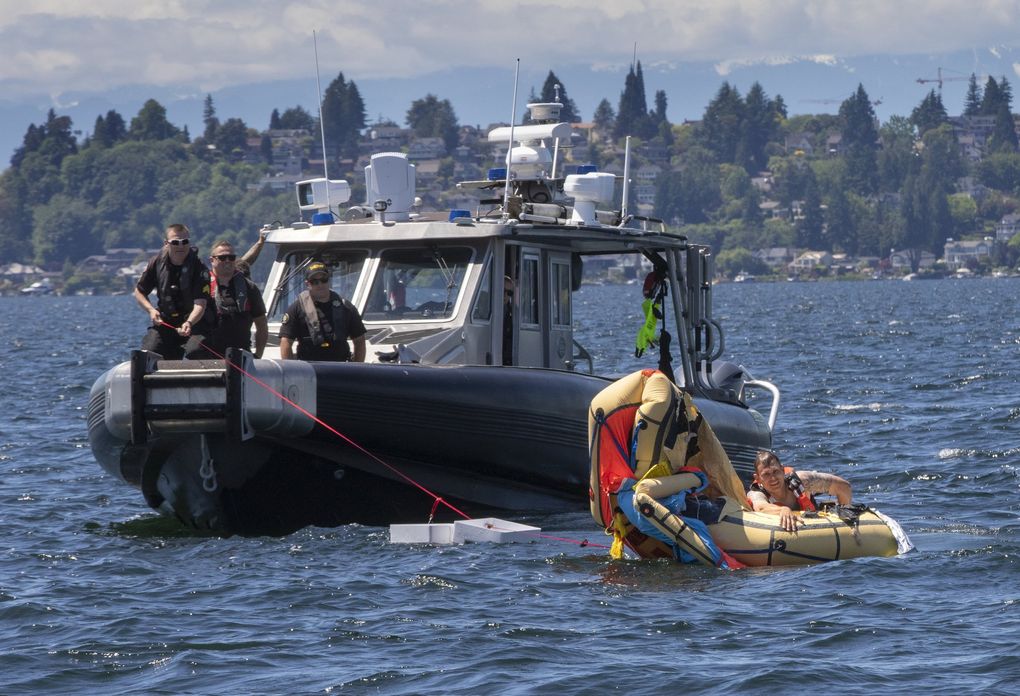 After the King County Sheriff’s marine rescue dive unit throws an inflatable raft into the water, Deputy Erik Pierson jumps in to straighten it out during a training day earlier this month. (Ellen M. Banner / The Seattle Times)