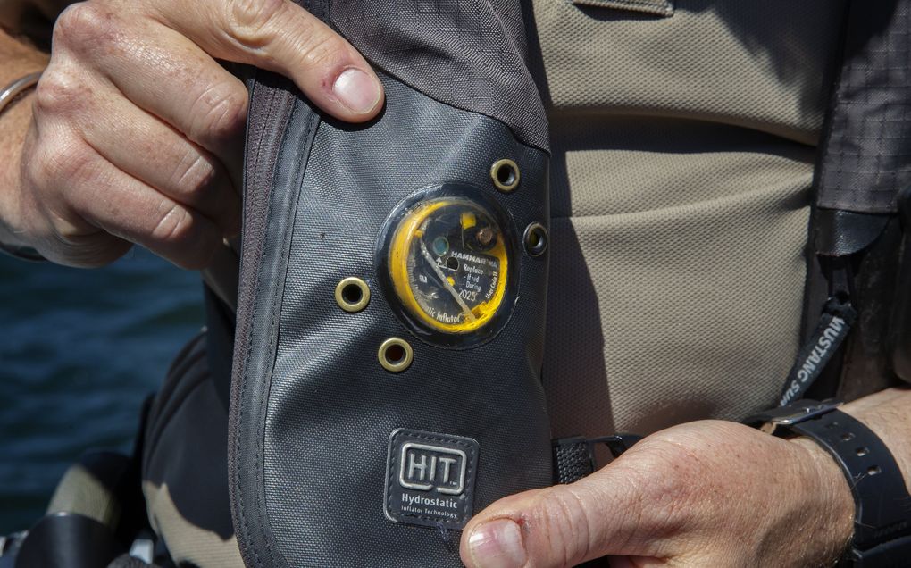 During a training drill with the King County Sheriff’s Office, Deputy Benjamin Callahan talks about a hydrostatic sensor that allows the self-acting inflatable personal flotation device he is wearing to inflate if the wearer falls into the water. A tablet inside the sensor dissolves when exposed to water and releases a firing pin that allows the CO2 cartridge to fire and inflate the vest. (Ellen M. Banner / The Seattle Times)