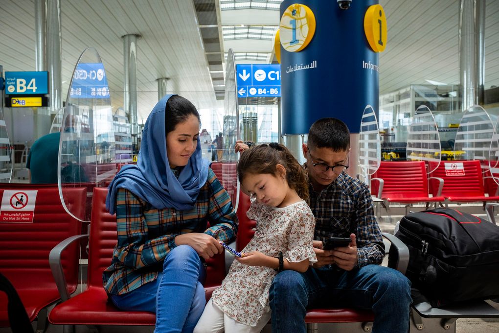 Afghan Air Force Maj. Naiem Asadi, his wife, Rahima, and their daughter, Zainab, wait for their flight to New York at the airport in Dubai, United Arab Emirates, on June 1, 2021. (Kiana Hayeri / The New York Times)