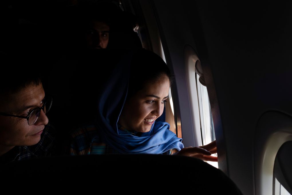 The Asadis look out at the Persian Gulf, seeing a body of water for the first time in their lives, as their plane descends into Dubai, United Arab Emirates, on June 1, 2021. (Kiana Hayeri / The New York Times)