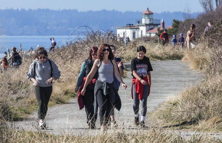 **EMBARGO: for Weekend Plus story running next week please. AG**

Thursday, March 19, 2020.   Walkers on South Beach Trail in the unusual sunshine at Discovery Park. West Point Lighthouse is in the backround.   213392