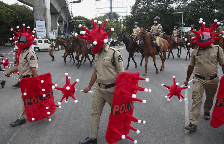 Indian police officers walk wearing virus themed helmet during an awareness drive aimed at preventing the spread of the coronavirus in Hyderabad, India, Wednesday, June 9, 2021. (AP Photo/Mahesh Kumar A.) 