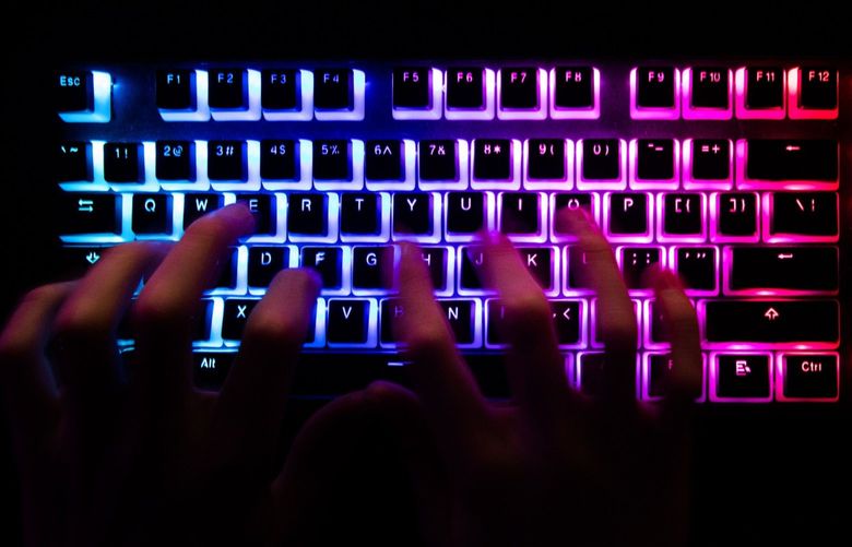 A person typing at a backlit computer keyboard in Danbury, U.K., on Tuesday, Dec. 29, 2020. In the spring, hackers managed to insert malicious code into a software product from an IT provider called SolarWinds, whose client list includes 300,000 institutions. MUST CREDIT: Bloomberg photo by Chris Ratcliffe