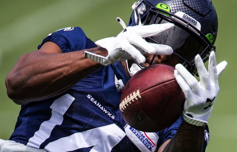 Seahawks wide receiver DK Metcalf bobbles a pass but pulls it down as the Seattle Seahawks hold Organized Team Activities Thursday June 10, 2021 at the Virginia Mason Athletic Center in Renton.  217336