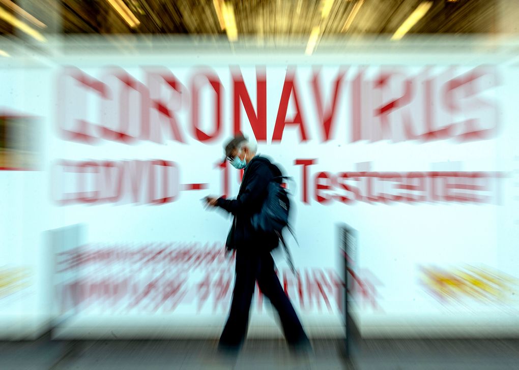 In this Feb. 25, 2021 file photo a man walks by a sign in the window of a Coronavirus testing center in Frankfurt, Germany. (AP Photo/Michael Probst, file)