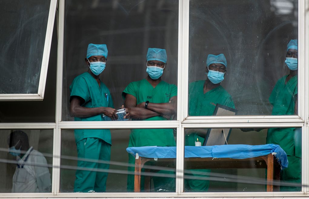 FILE – In this March 5, 2021, file photo, medical staff look out from a window as officials prepare for a ceremony to commence the country’s first coronavirus vaccinations using AstraZeneca provided through the global COVAX initiative, at Kenyatta National Hospital in Nairobi, Kenya. In the global race to vaccinate people against COVID-19, Africa is tragically at the back of the pack. And hundreds of thousands of the country’s health workers, many of whom come face-to-face with the virus every day, are still waiting for their shots. (AP Photo/Ben Curtis, File)