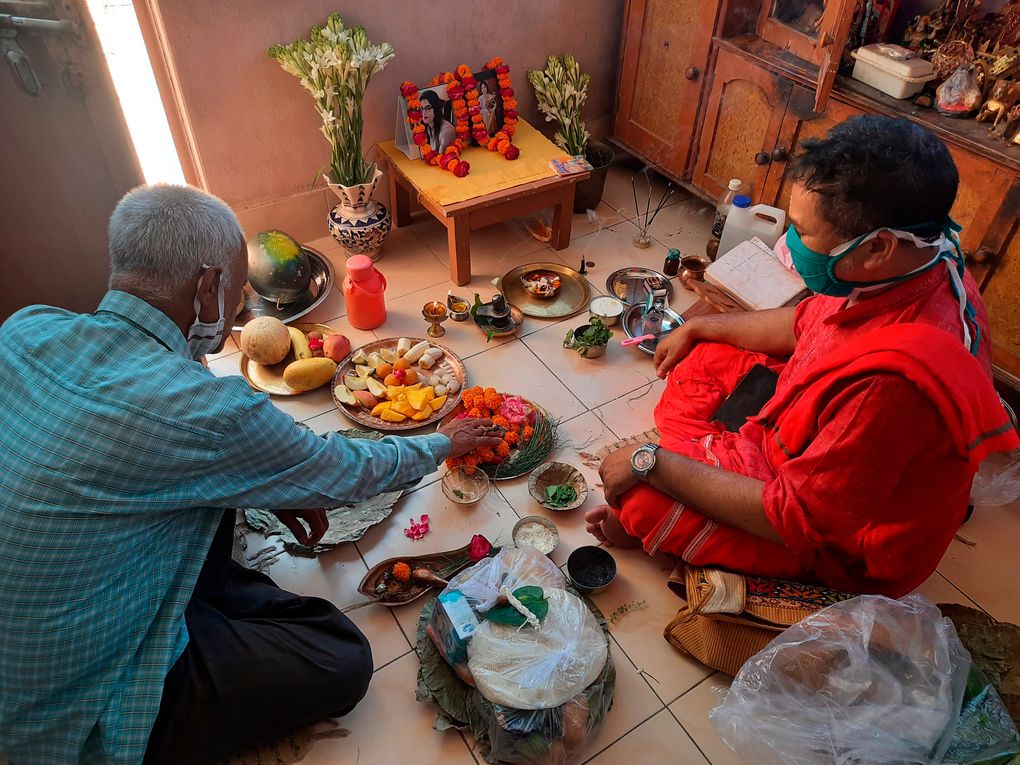 Radha Gobindo Pramanik, left, performs a Hindu ritual for his wife and daughter who died of COVID-19 at his home in Lucknow, India, May 23, 2021. “Everyone whom I loved the most has left me,” the 71-year-old said on a recent night as a Hindu priest chanted mantras and performed a ritual for the dead at his home in the northern city of Lucknow. “I am left alone in this world now.” (AP Photo/Rajesh Kumar Singh)