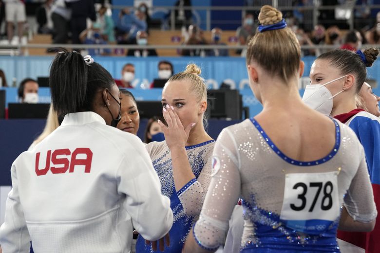 Simone Biles, of the United States, congratulates gymnasts from the Russian Olympic Committee’s Liliia Akhaimova, back to camera, Vladislava Urazova, right, and Angelina Melnikova after they won the gold medal at the 2020 Summer Olympics, Tuesday, July 27, 2021, in Tokyo.(Ashley Landis / AP)