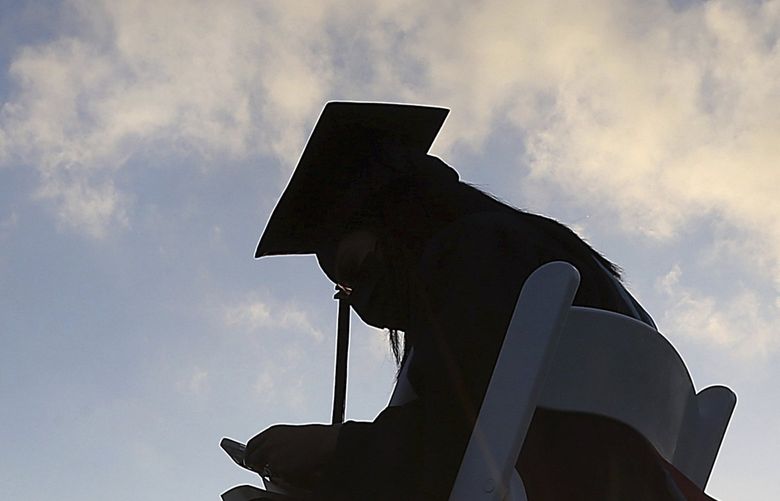 FILE – In this May 7, 2021 file photo, University of Texas Rio Grande Valley graduates sit social distanced in the early morning sunrise during their commencement ceremony at the schools parking lot in Edinburg, Texas. (Delcia Lopez/The Monitor via AP)
student aid loan fafsa grad debt