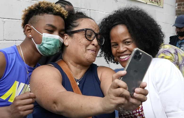 Boston’s acting Mayor Kim Janey, right, takes a selfie with attendees as she meets people in Boston’s Nubian Square for a Juneteenth commemoration, Friday, June 18, 2021, in Boston. (AP Photo/Elise Amendola) MAEA102 MAEA102
