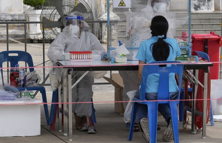Health workers collect nasal swabs from local residents for coronavirus testing at the Ratchasingkhon temple in Bangkok, Thailand, Wednesday, July 7, 2021. (AP Photo/Sakchai Lalit) XSL102 XSL102