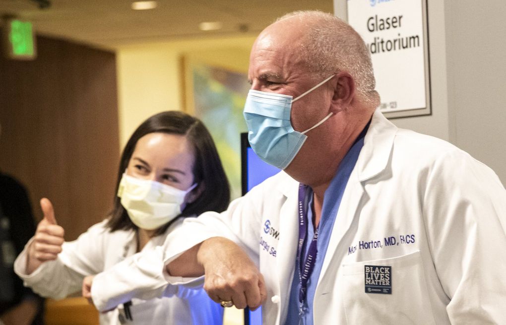 Dr. Marc Horton and Dr. Naomi Diggs elbow bump after both receiving the Pfizer coronavirus vaccine at Swedish on Tuesday.
Health-care workers are the first to get initial doses of Pfizer’s coronavirus vaccine in Seattle. The workers will receive a second dose of the vaccine in a few weeks.
(Amanda Snyder / The Seattle Times)
