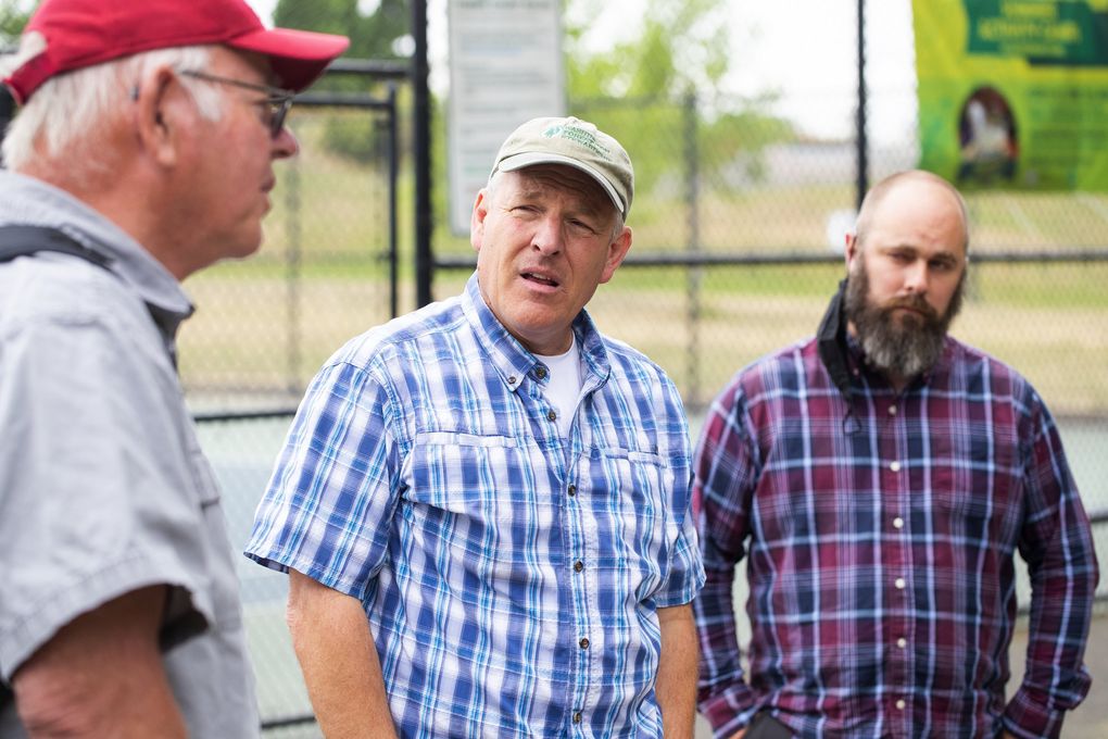 From left, Gary Chastagner, professor of plant pathology for WSU, Dan Omdal, forest pathologist for Washington Department of Natural Resources, and Nicholas Johnson, arborist for Seattle Parks and Recreation, talk about sooty bark disease at Jefferson Park in Seattle’s Beacon Hill neighborhood Friday July 2, 2021. Sooty bark is a fungal infection that produces visible black spores and causes the tree to shed bark. It is potentially harmful to human lungs when the spore is airborne during tree work and removal. (Bettina Hansen / The Seattle Times)