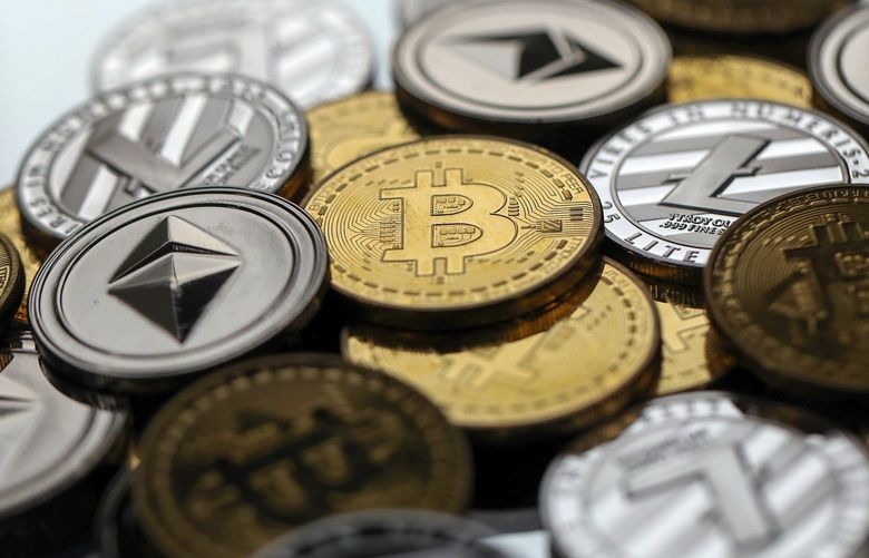 A collection of bitcoin, litecoin and ethereum tokens sit in this arranged photograph in Danbury, U.K., on Tuesday, Oct. 17, 2017. On Wednesday, billionaire Warren Buffett said on CNBC that most digital coins won’t hold their value.