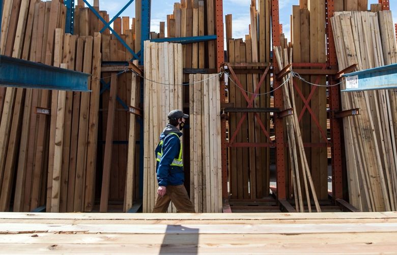 A worker walks past rows of lumber at a lumberyard in Victoria, British Columbia, Canada, on Friday, May 7, 2020. The pandemic-fueled surge in home construction last year took North American sawmills by surprise, sending lumber prices to new records. Photographer: James MacDonald/Bloomberg