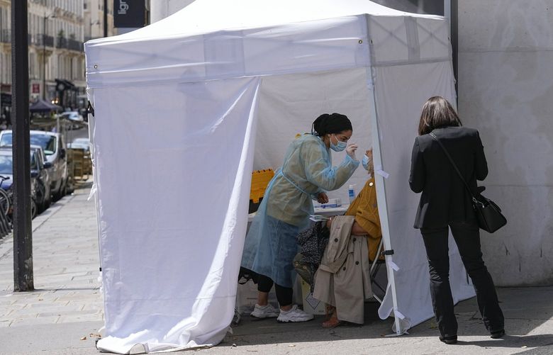 A medical technician administers nasal swabs at a mobile testing site in Paris, Monday, July 12, 2021. France’s President Emmanuel Macron is hosting a top-level virus security meeting Monday morning and then giving a televised speech Monday evening, the kind of solemn speech he’s given at each turning point in France’s virus epidemic.(AP Photo/Michel Euler) 