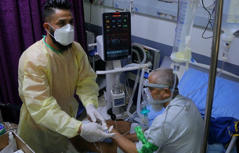 A coronavirus patient receives treatment at a hospital in Najaf, Iraq, Wednesday, July 14, 2021. Infections in Iraq have surged to record highs amid a third wave spurred by the more aggressive delta variant, and long-neglected hospitals suffering the effects of decades of war are overwhelmed with severely ill patients. (AP Photo/Anmar Khalil) BAG112 BAG112