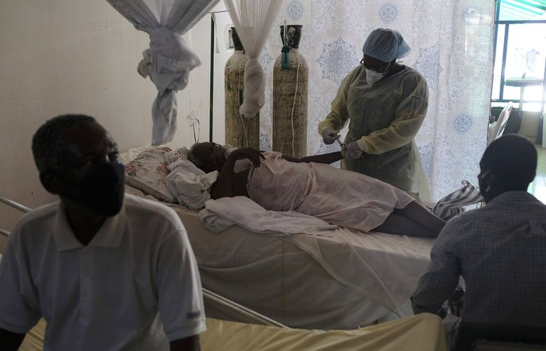 A healthcare worker attends to a COVID-19 patient in the intensive care unit of the Saint Luke Foundation for Haiti Hospital in Port-au-Prince, Haiti, Saturday, July 17, 2021, amid the new coronavirus pandemic. (AP Photo/Matias Delacroix) XMD106 XMD106