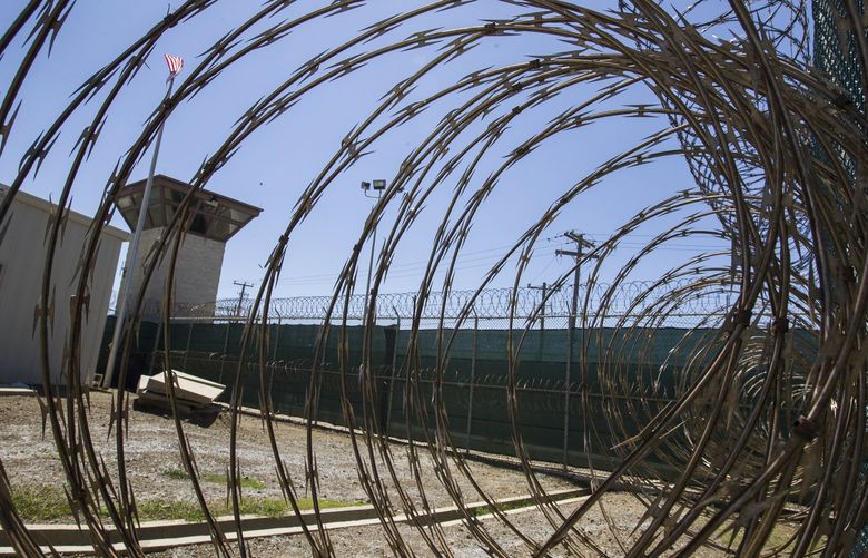 FILE – In this Wednesday, April 17, 2019 file photo reviewed by U.S. military officials, the control tower is seen through the razor wire inside the Camp VI detention facility in Guantanamo Bay Naval Base, Cuba. The Biden administration has transferred a detainee out of the GuantÃ(degrees)namo Bay detention facility for the first time, sending a Moroccan man back home years after he was recommended for discharge. (AP Photo/Alex Brandon, File) WX101 WX101