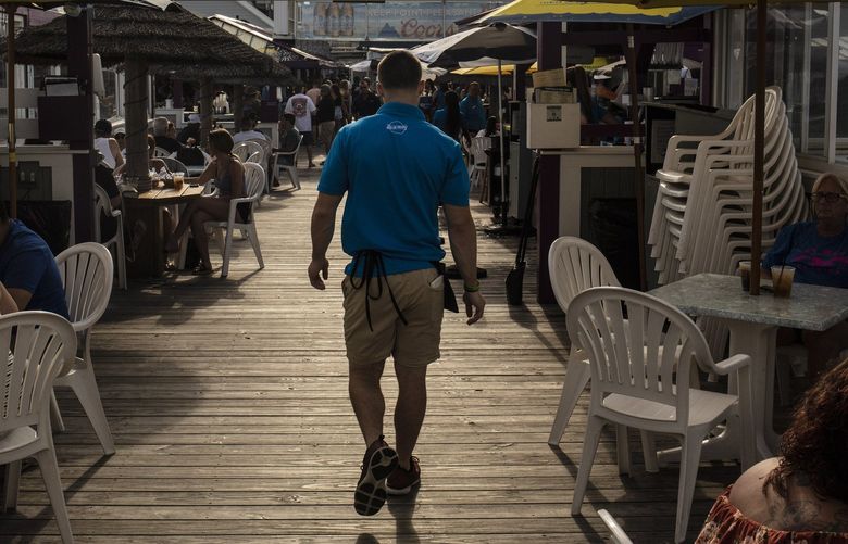FILE — A waiter at a bar in Point Pleasant, N.J., June 18, 2021. The sharp rebound in hiring, especially in service industries, is widening opportunities and prompting employers to compete on pay. (Bryan Anselm/The New York Times) XNYT22 XNYT22