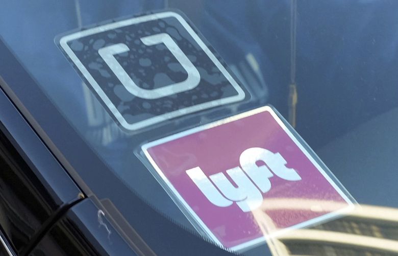 FILE – In this Jan. 12, 2016, file photo, a ride share car displays Lyft and Uber stickers on its front windshield in downtown Los Angeles. Law enforcement agencies and ride-hailing companies are intensifying efforts to warn passengers against getting in without checking to ensure both the vehicle and driver are legitimate. (AP Photo/Richard Vogel, File)