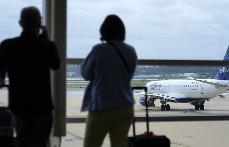 FILE – In this Tuesday, May 25, 2021, file photo, travelers watch a JetBlue Airways aircraft taxi away from a gate at Ronald Reagan Washington National Airportâ€ ahead of Memorial Day weekend, in Arlington, Va. Sen. Maria Cantwell, D-Wash., who chairs the Senate Commerce Committee, sent letters Friday, July 16, 2021, to the CEOs of American, Southwest, Delta, JetBlue, Republic and Allegiant. She wrote that she is concerned by reports that have highlighted the role of worker shortages in a surge of delayed and canceled flights. (AP Photo/Patrick Semansky, File) NYPH803 NYPH803