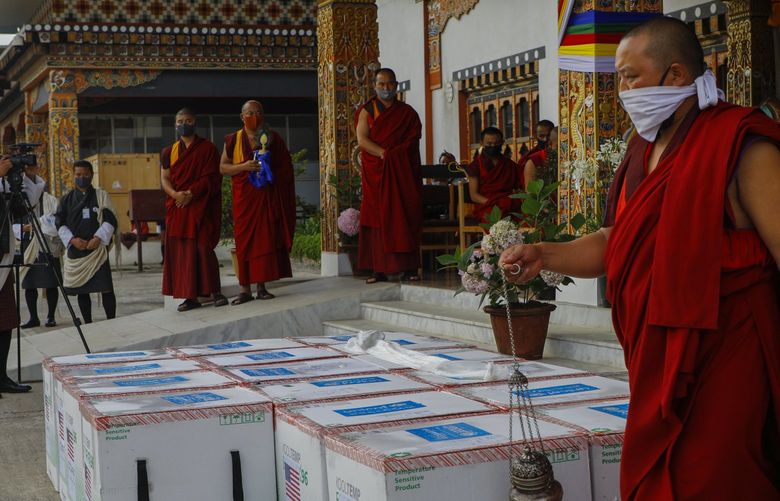 This photograph provided by UNICEF shows monks from Paro’s monastic body perform a ritual as 500,000 doses of Moderna COVID-19 vaccine gifted from the United States arrived at Paro International Airport in Bhutan, July 12, 2021. The Himalayan kingdom of Bhutan has fully vaccinated 90% of its eligible adult population within just seven days, its health ministry said Tuesday. (UNICEF via AP) 