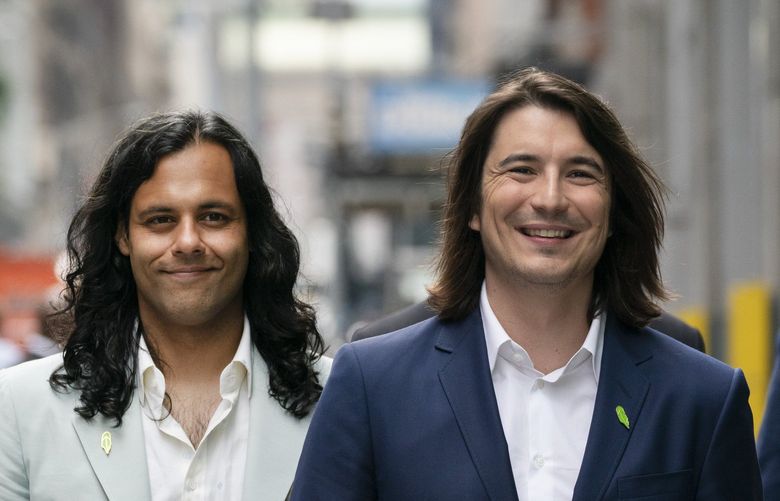 Vladimir Tenev, CEO and co-founder of Robinhood, right, walks in New York’s Times Square with Baiju Bhatt, also co-founder, following their company’s IPO, Thursday, July 29, 2021. Robinhood is selling its own stock on Wall Street, the very place the online brokerage has rattled with its stated goal of democratizing finance. Through its app, Robinhood has introduced millions to investing and reshaped the brokerage industry, all while racking up a long list of controversies in less than eight years. (AP Photo/Mark Lennihan) NYML107 NYML107