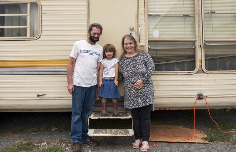Scott Ludwig and Kristina Bowen with their three-year-old daughter Cheyenne outside the trailer they live in at the evacuation center at Springs of Hope Christian Church on Friday, July 30, 2021, in Quincy, Calif.  In what has grown into a grim ritual as wildfires plague Northern California, thousands have had to flee their homes. (Nic Coury/The New York Times) XNYT194 XNYT194
