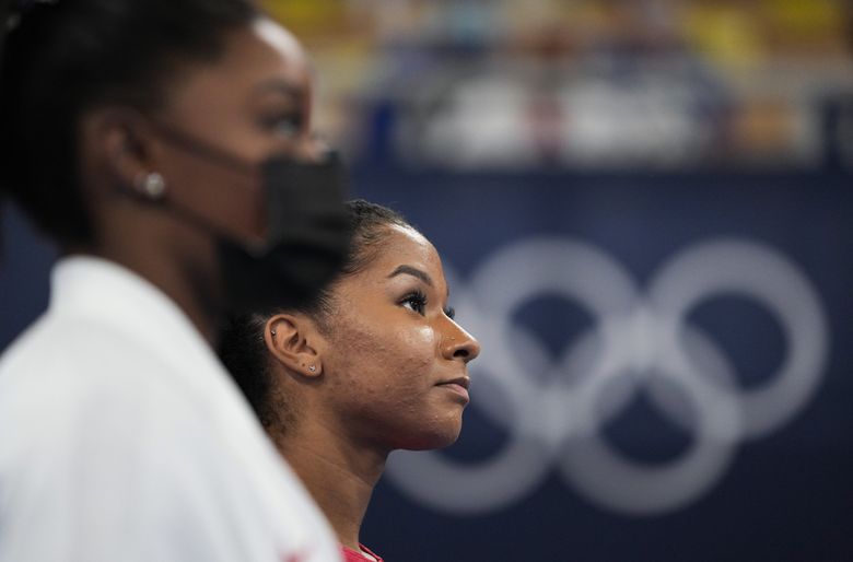Simone Biles, left, stands with teammate Jordan Chiles after Chiles’ performance on the uneven bars Tuesday at the Olympics in Tokyo. Chiles, of Vancouver, Washington, was called upon after Biles abruptly withdrew from team competition, citing a need to “work on my mindfulness.”  (Ashley Landis / The Associated Press)