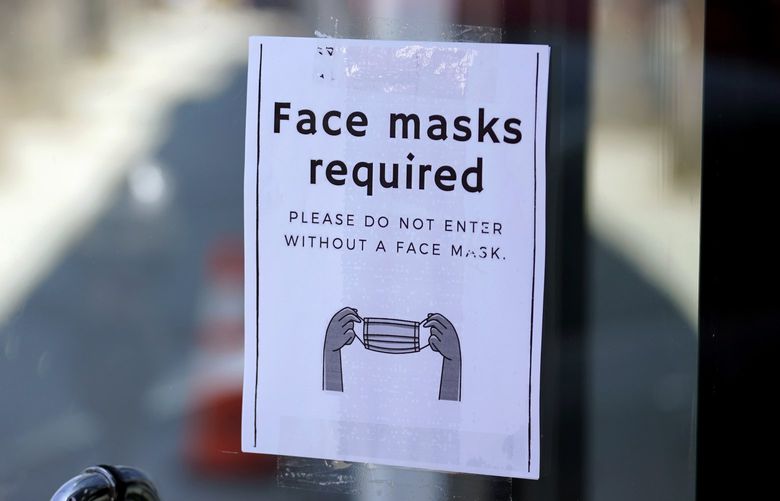 FILE – A sign advises shoppers to wear masks outside of a store Monday, July 19, 2021, in the Fairfax district of Los Angeles. Infections are climbing across the U.S. and mask mandates and other COVID-19 prevention measures are making a comeback in some places as health officials issue increasingly dire warnings about the highly contagious delta variant. But in a possible sign that the warnings are getting through to more Americans, vaccination rates are creeping up again, offering hope that the nation could yet break free of the coronavirus if people who have been reluctant to receive the shot are finally inoculated. (AP Photo/Marcio Jose Sanchez, File) NYCD253 NYCD253