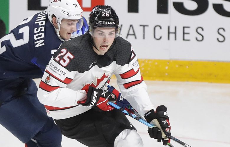 Canada’s Owen Power, right, challenges for the puck with Tage Thompson of the US during the Ice Hockey World Championship semifinal match between the United States and Canada at the Arena in Riga, Latvia, Saturday, June 5, 2021. (AP Photo/Sergei Grits)