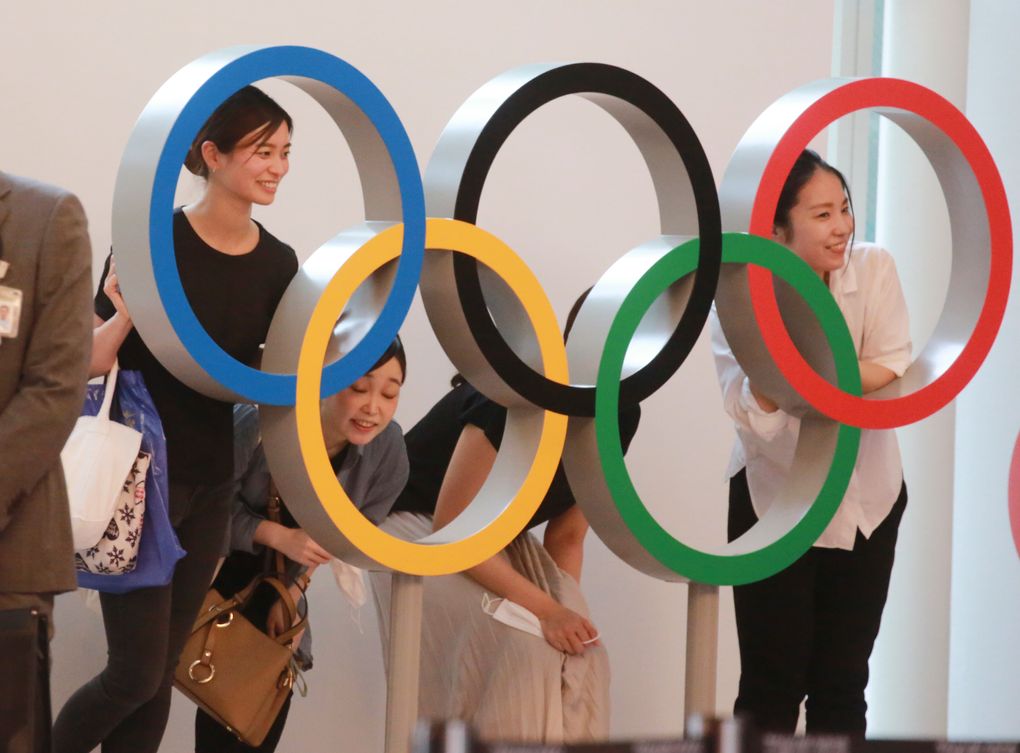 People pose for photo with the Olympics Rings display at Haneda International Airport in Tokyo, Thursday, July 8, 2021. (AP Photo/Koji Sasahara)