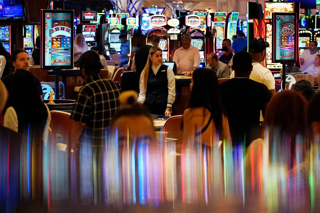 FILE – In this June 24, 2021, file photo, crowds walk through the casino during the opening night of Resorts World Las Vegas in Las Vegas. Masks are back in Las Vegas, where regional health officials pointed Friday, July 16, 2021, to a rising number of coronavirus cases and advised everyone, vaccinated or not, to wear facial coverings in crowded indoor places. Seven weeks ago, Nevada fully lifted coronavirus restrictions and returned pandemic control measures to counties. (AP Photo/John Locher, File)