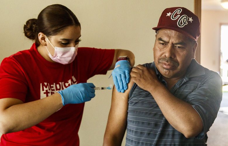 Medical assistant Reina Perez, left, vaccinates Camerino Vasquez at a pop-up clinic for migrant workers put on by Medical Teams International in Malaga, Wash. located in Chelan County on Thursday, July 15, 2021.

County-level Covid-19 vaccination data reveals large gaps for Hispanic and Black residents. In Chelan and Douglas County, vaccination rates among the Hispanic population are higher than other counties in Washington state.