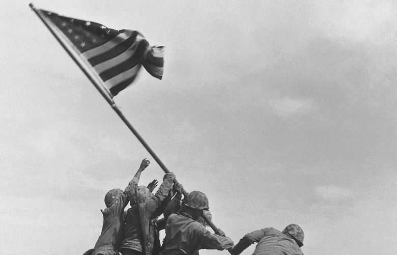 FILE – U.S. Marines of the 28th Regiment, 5th Division, raise the American flag atop Mt. Suribachi, Iwo Jima, on Feb. 23, 1945 during World War II. (AP Photo/Joe Rosenthal, File) NY509