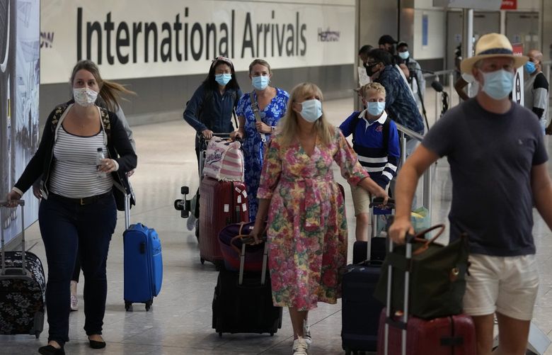 Passengers arrive at Terminal 5 of Heathrow Airport in London, Monday, Aug. 2, 2021. Travelers fully vaccinated against coronavirus from the United States and much of Europe were able to enter Britain without quarantining starting today, a move welcomed by Britain’s ailing travel industry. (AP Photo/Matt Dunham) LMD125 LMD125