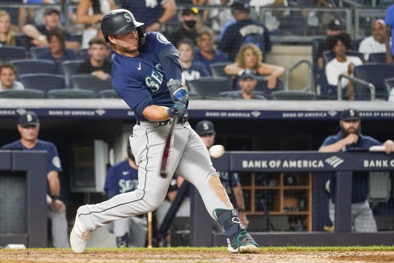 Seattle Mariners' Tom Murphy reacts in the dugout after he hit a