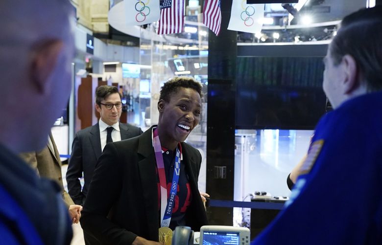 USA Women’s Olympic Water Polo gold medal goalkeeper Ashleigh Johnson chats with a pair of specialists on the the New York Stock Exchange trading floor, after she rang opening bell, Tuesday, Aug. 10, 2021. (AP Photo/Richard Drew) NYRD205 NYRD205