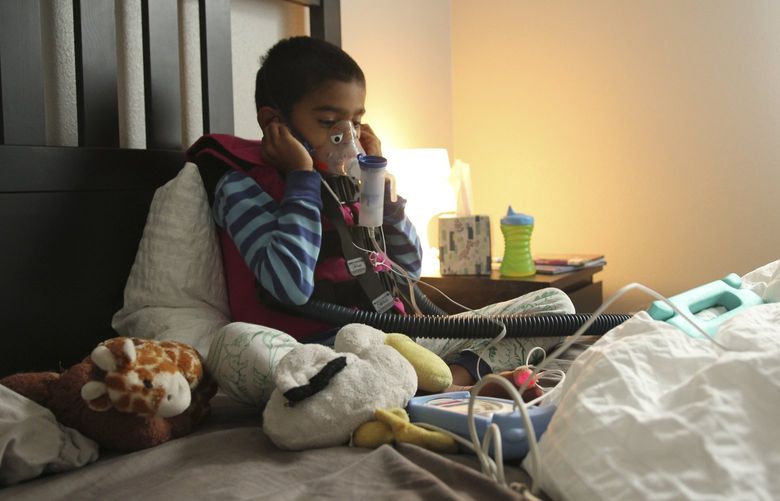 In an undated image provided by Alison Chandra, Alison Chandra’s son, Ethan, who has heterotaxy syndrome, which makes it difficult for his lungs to clear mucus, wearing his medical vest and using a nebulizer. When Ethan tested positive for the coronavirus, his mother vented her frustration on social media, blaming low vaccination rates in Utah. (Alison Chandra via The New York Times) – NO SALES; FOR EDITORIAL USE ONLY WITH NYT STORY VIRUS CHILDREN RISK BY AMANDA MORRIS FOR AUG. 9, 2021. ALL OTHER USE PROHIBITED.  –