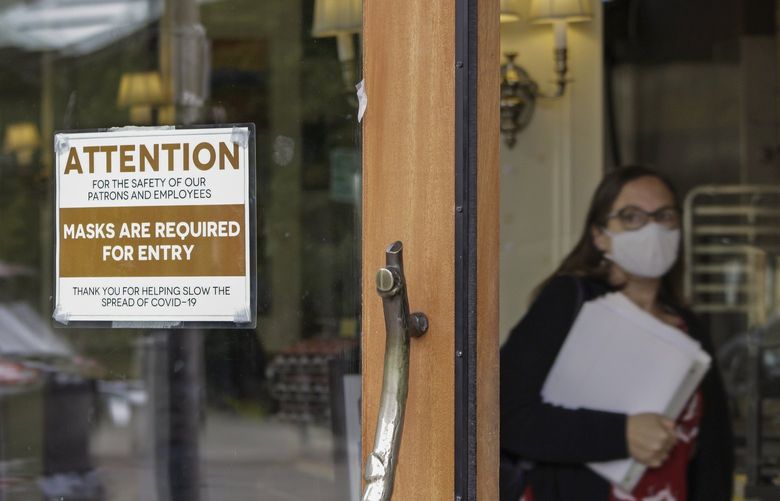 FILE – In this May 21, 2021 file photo, a sign reminds customers to wear their masks at a bakery in Lake Oswego, Ore. Oregon Gov. Kate Brown on Tuesday, Aug. 10, 2021 announced a statewide indoor mask requirement due to the spike in COVID-19 hospitalizations and cases, warning that the state’s health care system could be overwhelmed. (AP Photo/Gillian Flaccus, File) LA354 LA354