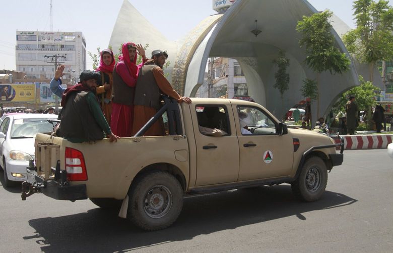Taliban fighters pose on the back of a vehicle in the city of Herat, west of Kabul, Afghanistan, Saturday, Aug. 14, 2021, after they took this province from Afghan government. The Taliban seized two more provinces and approached the outskirts of Afghanistanâ€™s capital. (AP Photo/Hamed Sarfarazi) XRG104 XRG104