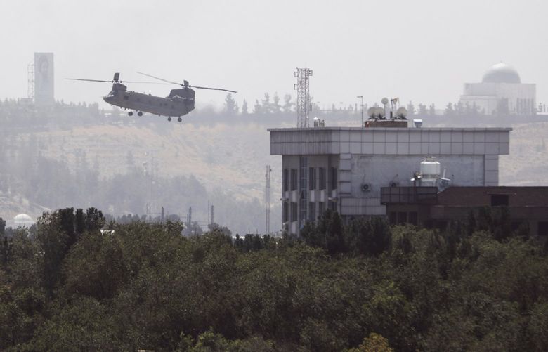 A U.S. Chinook helicopter flies near the U.S. Embassy in Kabul, Afghanistan, Sunday, Aug. 15, 2021. Helicopters are landing at the U.S. Embassy in Kabul as diplomatic vehicles leave the compound amid the Taliban advanced on the Afghan capital. (AP Photo/Rahmat Gul) XRG109 XRG109