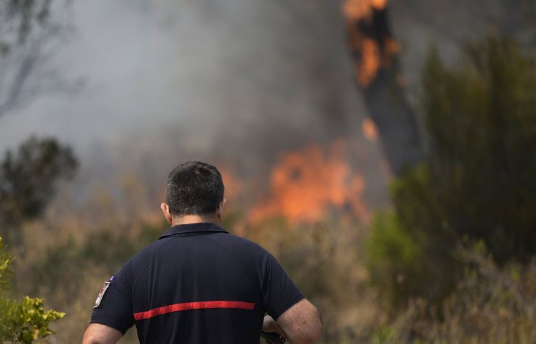 A fireman approaches a fire in a forest near Le Luc, southern France, Tuesday, Aug. 17, 2021. Thousands of people were evacuated from homes and vacation spots near the French Riviera as firefighters battled a fire racing through surrounding forests Tuesday, the latest of several wildfires that have swept the Mediterranean region. (AP Photo/Daniel Cole) MAR110 MAR110