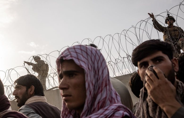 American soldiers aim at a man who tried to climb across the wall at Hamid Karzai International Airport in Kabul, Afghanistan, Aug. 22, 2021. (Jim Huylebroek/The New York Times) XNYT13 XNYT13