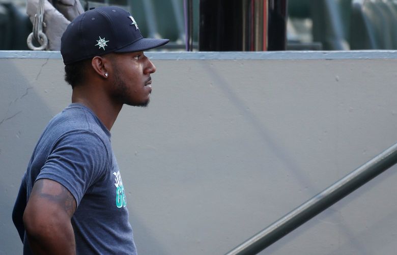 Mariners outfielder Kyle Lewis, still out  of the lineup after knee surgery, watches batting practice from the dugout before a game against the Astros, Monday, July 26, 2021 in Seattle. Lewis played catch before the game Monday and he’s started hitting off the tee and in the cage, but has yet to do any sort of baseball activity on the field other than playing catch, Ryan Divish reports. 217746